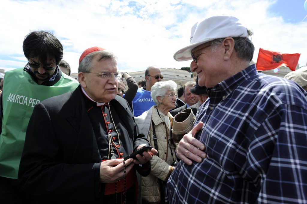 U.S. Cardinal Raymond L. Burke, prefect of the Supreme Court of the Apostolic Signature and a former archbishop of St. Louis, speak to a man during a May 4 pro-life demonstration in St. Peter's Square at the Vatican. Catholic politicians and judges who support laws in conflict with church teaching on abortion, euthanasia, marriage and related issues commit "sacrilege" and cause "grave scandal" if they receive Communion, the cardinal told an international conference of pro-life organizations. (CNS photo/Katarzyna Artymiak)