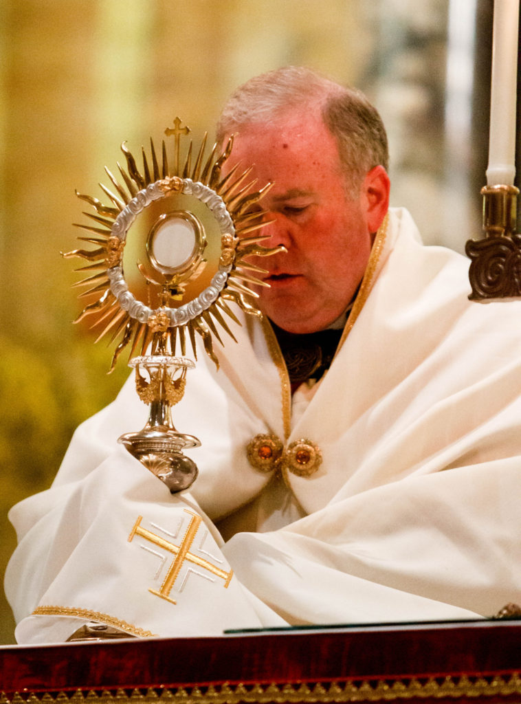 Harvard University chaplain Fr. Michael Drea holds the monstrance during a May 12 holy hour at St. Paul Church in Cambridge, Mass. The service was held in reaction to plans for a satanic ritual "black mass" to take place in a pub on the Harvard campus . The student group organizing the satanic event ultimately cancelled it. (CNS photo/Gregory L. Tracy, Pilot)