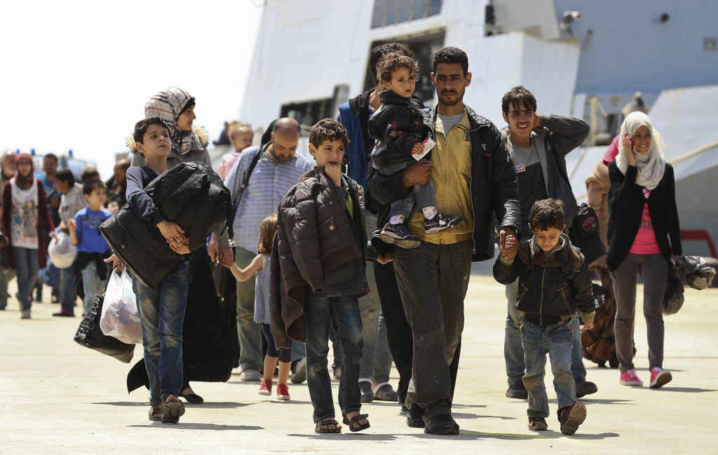 Migrants walk as they disembark from a navy ship in the Sicilian harbor of Augusta May 22. More than 100 children were among the 488 migrants rescued by the Italian navy off the Sicilian coast on May 21 as the influx of arrivals continues, spurred on by the unstable political situation in Libya. Priests in Tripoli and Benghazi say Catholics are "living in fear" as a conflict with Islamists nears a showdown in Libya. (CNS photo/Antonio Parrinello, Reuters)