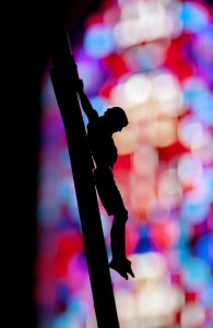 A crucifix is silhouetted against a stained-glass window at the chapel inside Elmira Correctional Facility, a maximum security prison in Elmira, N.Y. March 18. (CNS photo/Mike Crupi, Catholic Courier)