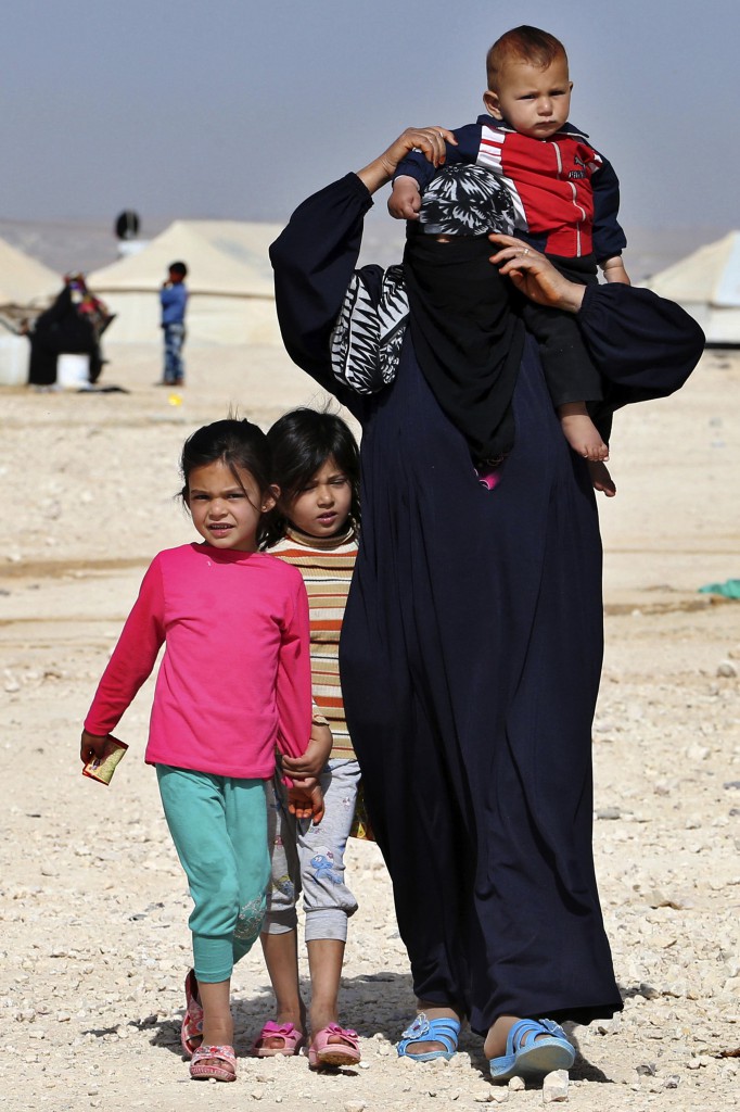 Syrian refugee children walk with their grandmother at Al Zaatri refugee camp in the Jordanian city of Mafraq, near the border with Syria, May 4. Fleeing conflict and violence refugees from Syria and Iraq praise the Catholic humanitarian agencies helping them cope with trauma while starting a new life in their adopted safe haven of Jordan. (CNS photo/Muhammad Hamed, Reuters)