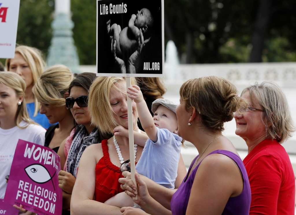 A pro-life demonstrator holds her child as activists gather outside the U.S. Supreme Court in Washington June 26 to celebrate the court decision striking down a Massachusetts law that mandated a buffer zone to keep pro-life demonstrators away from abortion clinics. (CNS photo/Jim Bourg, Reuters)
