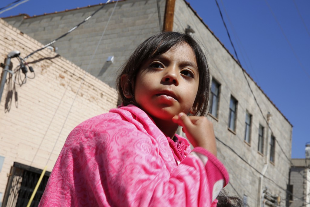 Three-year-old Monica Dabdoub makes the sign of the cross as she attends Mass with her mother at the border fence in Nogales, Ariz., April 1. The Mass was celebrated by a group of visiting U.S. bishops during on a two-day tour of the border region. The bishops used their visit to call attention to the plight of migrants and to appeal for changes in U.S. immigration policy. (CNS photo/Nancy Wiechec)