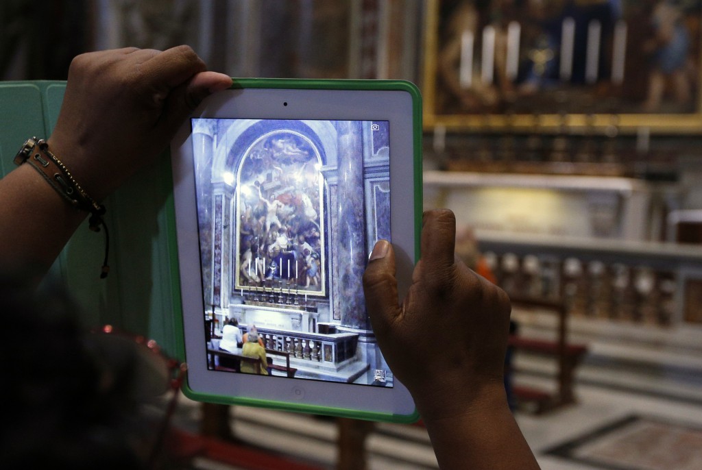 A visitor uses an iPad to take a photo of the tomb of Blessed John Paul II in St. Peter's Basilica at the Vatican in this 2013 file photo. (CNS photo/Paul Haring) 