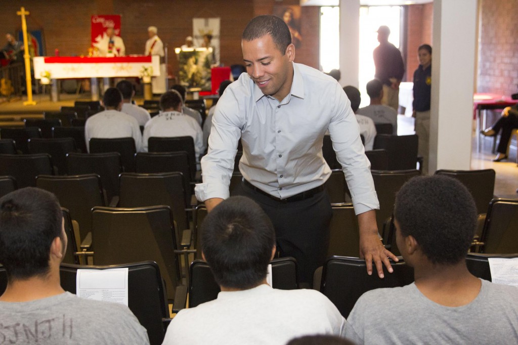 Xavier McElrath-Bey, sentenced to 25 years in prison at the age of 13 and now an advocate for juveniles, offers sign of peace to incarcerated minors during a June 8 Mass at Barry J. Nidorf Juvenile Hall in Sylmar, Calif., where a letter from Pope Francis to the youth was read. More than 500 incarcerated juveniles wrote to the pope on the subject of fairness in sentencing. (CNS photo/Courtesy of the Archdiocese of Los Angeles)