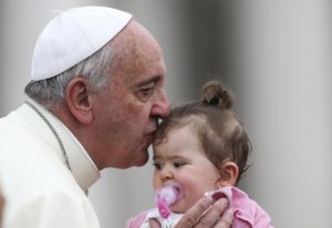 Pope Francis kisses a child during his June 25 general audience in St. Peter's Square at the Vatican. (CNS photo/Alessandro Bianchi, Reuters)