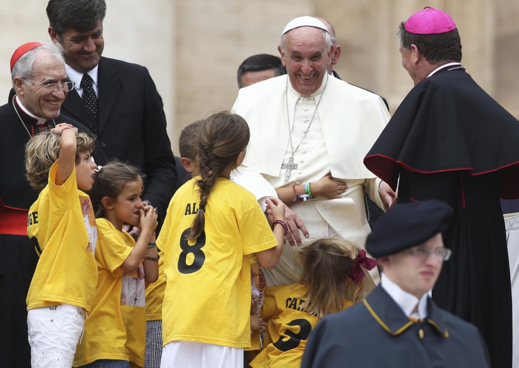 Pope Francis smiles as he meets children during his June 25 general audience in St. Peter's Square at the Vatican. (CNS photo/Alessandro Bianchi, Reuters)