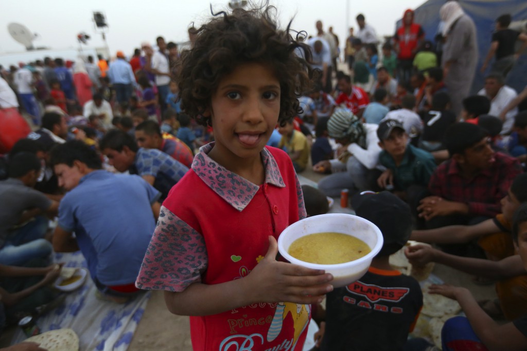 A child holds a bowl of soup inside the Khazer camp on the outskirts of Irbil, Iraq, June 29. Chaldean Catholic bishops, meeting for their annual synod in Irbil, appealed for courageous dialogue to pull the embattled country out from the dark tunnel.  (CNS photo/Stringer, Reuters)