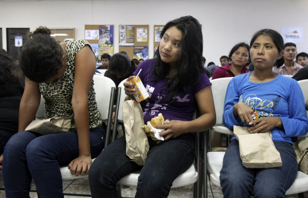 Migrants from Guatemala who have been deported from the U.S. wait to provide their personal information to immigration authorities July 10 after arriving at La Aurora International Airport in Guatemala City. A growing wave of families and unaccompanied minors fleeing Guatemala, El Salvador and Honduras are streaming by the thousands into the U.S. (CNS photo/Pakal Koban, Reuters)
