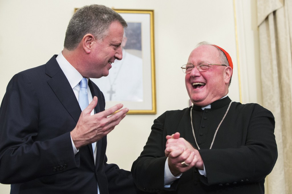 New York City Mayor Bill de Blasio laughs with New York Cardinal Timothy M. Dolan following a meeting at the cardinal's residence in the Manhattan borough of New York Jan. 13. De Blasio met with Cardinal  Dolan for the first time since he took office, declaring he will join forces with the cardinal to convince Pope Francis to visit New York City. (CNS photo/Lucas Jackson, Reuters)  