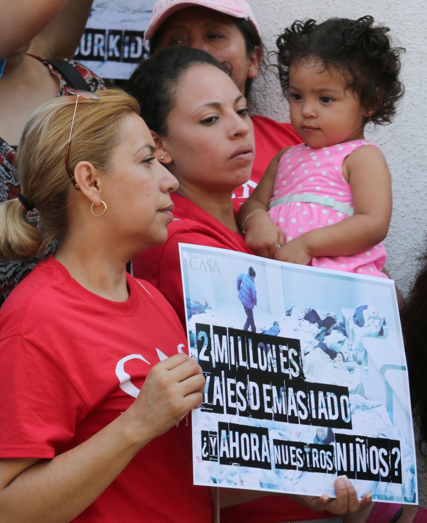 Immigrant families and immigration reform activists hold signs of protest during a July 7 news conference in Washington near the White House organizaed by Casa de Maryland and other pro-immigration reform groups. Several speakers at the event urged the Obama administration to provide relief for all children and their families who have crossed the U.S. border illegally to flee violence in Central America. (CNS photo/Chaz Muth)  