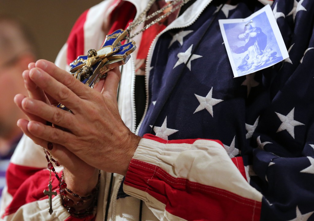 A worshipper holding a rosary and crucifix prays during a July 4 Mass celebrated at the Basilica of the National Shrine of the Immaculate Conception in Washington on the final day of the U.S. bishops' Fortnight for Freedom campaign. (CNS photo/Bob Roller )