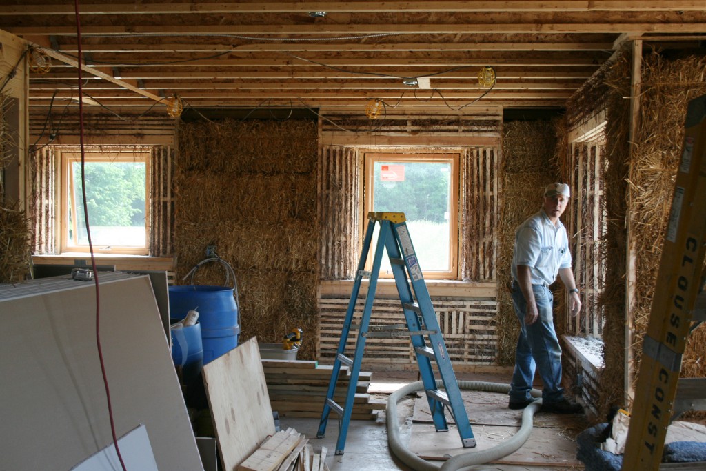 A worker puts straw bales inside the walls of a house using alternative construction materials on the grounds of the Sisters of St. Francis of Tiffin, Ohio. The religious order built the house as a demonstration project to show that by incorporating non- traditional materials and a renewable-energy system, a house -- or almost any structure -- can be comfortable and good for the environment. (CNS photo/courtesy Sisters of St. Francis of Tiffin)