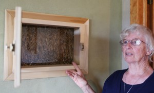 St. Francis Sister Jane Frances Omler shows straw-bale insulation in the exterior walls of the energy-efficient house she helped build in Tiffin, Ohio, in this July photo. The Sisters of St. Francis of Tiffin built the house as a demonstration project to show that by incorporating non-traditional materials and a renewable-energy system, a house -- or almost any structure -- can be comfortable and good for the environment. (CNS photo/Chaz Muth)