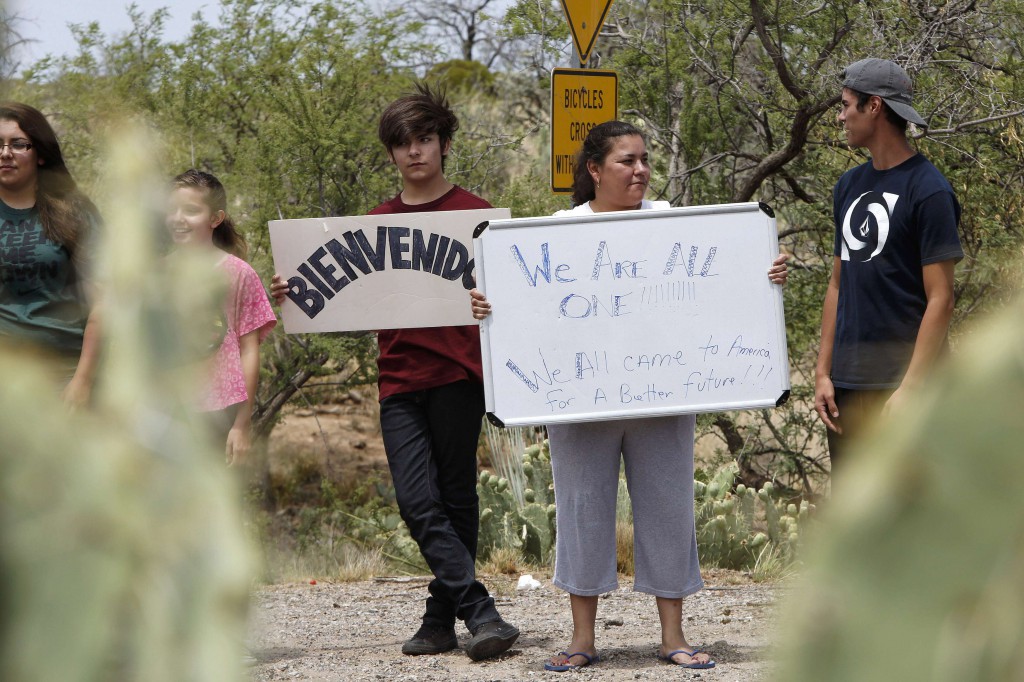Amelia Martinez of Oracle, Ariz., holds up a sign July 15 as she and members of her family gather in support of migrants in her town. In a scene reminiscent of similar protests in California, about 65 demonstrators gathered near Oracle to protest the arrival of immigrants who have entered the country illegally. They complained that the federal government's response to a surge of new arrivals from Central America was putting their communities at risk. (CNS photo/Nancy Wiechec, Reuters)