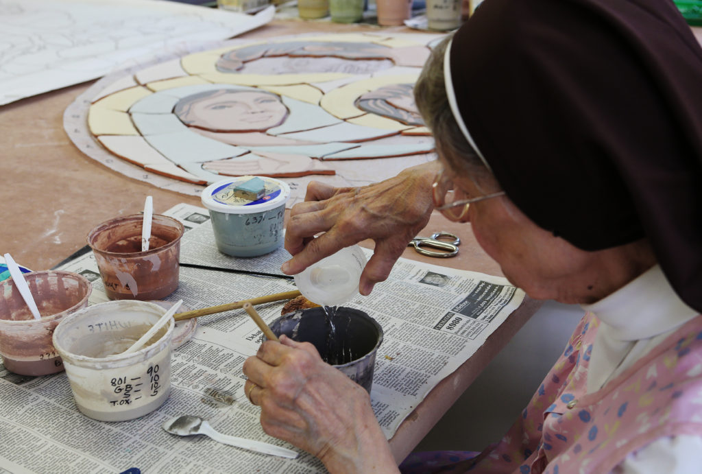 Franciscan Sister Jane Mary Sorosiak thins out some of the glaze she uses to paint clay murals she creates in a studio on the campus of Lourdes University in Sylvania, Ohio. Sister Jane Mary has been crafting murals with religious and spiritual themes for the past 38 years. (CNS photo/Chaz Muth)