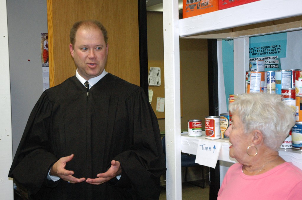 Judge David Certo, of the Indianapolis Community Court, talks with St. Patrick Parish volunteer Marsha Fecht, at the Officer David S. Moore Foundation Food Pantry at the court. The pantry is one of many efforts by the court to help offenders change their lives. "Our first priority is making our community safer," says Certo, a Catholic. "But how we're going to get there is a conversation we should have more often." (CNS photo/John Shaughnessy, The Criterion)
