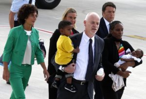 Meriam Ibrahim of Sudan carries one of her children as she arrives with Lapo Pistelli, Italy's vice minister for foreign affairs, holding her other child. Also picture is Italian Prime Minister Matteo Renzi, right, his wife Agnese, left, and Foreign Affairs minister Federica Mogherini. Ibrahim, who was spared a death sentence for converting from Islam to Christianity and then was barred from leaving Sudan, flew into Rome on July 24 in an Italian government plane. (CNS photo/Remo Casilli, Reuters)
