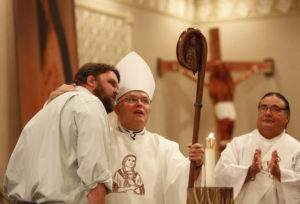 Archbishop Charles J. Chaput of Philadelphia receives a hand-carved crosier July 24 from artist Mark McAllister during the annual Tekakwitha Conference in Fargo, N.D. The staff features a likeness of St. Kateri Tekakwitha. (CNS photo/Nancy Wiechec)