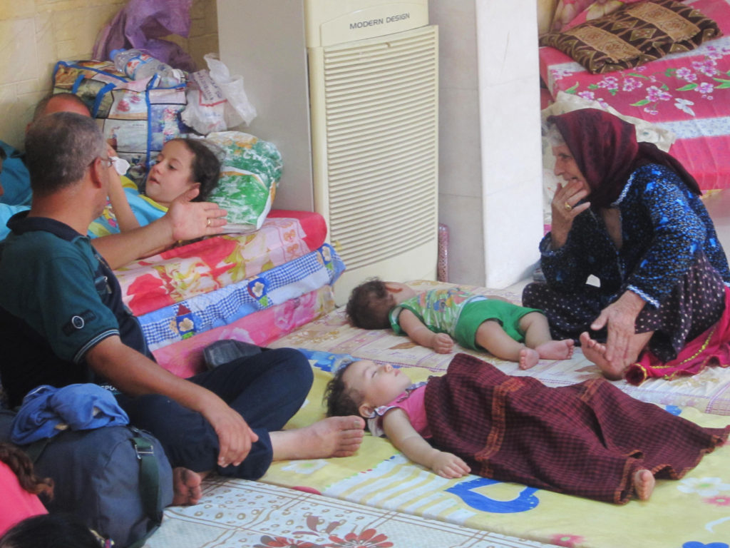 Iraqi Christian refugees rest at St JosephÕs Church in Ankawa, Iraq, Aug. 8. Witnesses claim refugees are dying in the crowded camps. (CNS photo/Sahar Mansour)