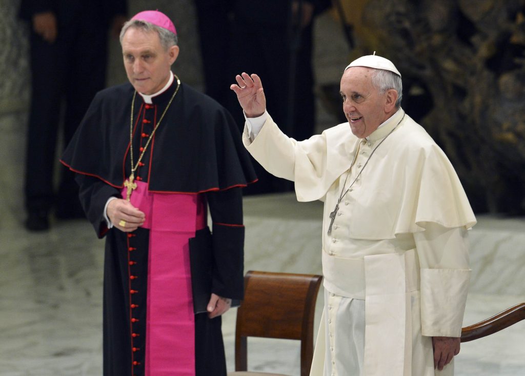 Pope Francis, flanked by Archbishop Georg Ganswein, prefect of the papal household, waves as he arrives to lead his weekly audience at the Vatican Aug. 6. More than 6,000 people filled the Vatican audience hall and its atrium for the pope's first general audience after a monthlong break. (CNS photo/Stefano Rellandini, Reuters) 