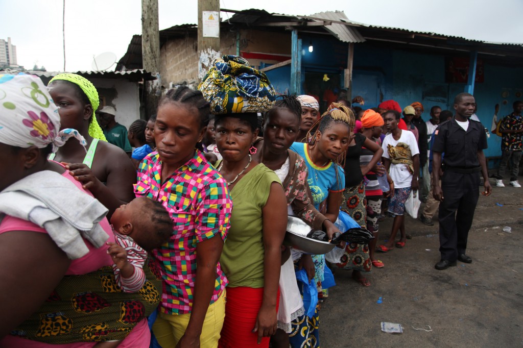 Residents of the West Point neighborhood of Monrovia, Liberia, wait for food rations to be handed out Aug. 21 as part of the government's quarantine plan for the area to fight the spread of the Ebola virus. Church workers say hunger and panic are major problems in Liberia and Sierra Leone as neighborhoods are sealed off or quarantined. (CNS photo/Ahmed Jallanzo, EPA)