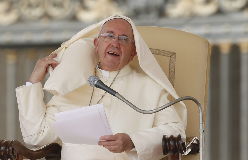 Pope Francis adjusts his mantle after it was blown by a gust of wind during his general audience in St. Peter's Square at the Vatican Aug. 27. (CNS photo/Paul Haring) 