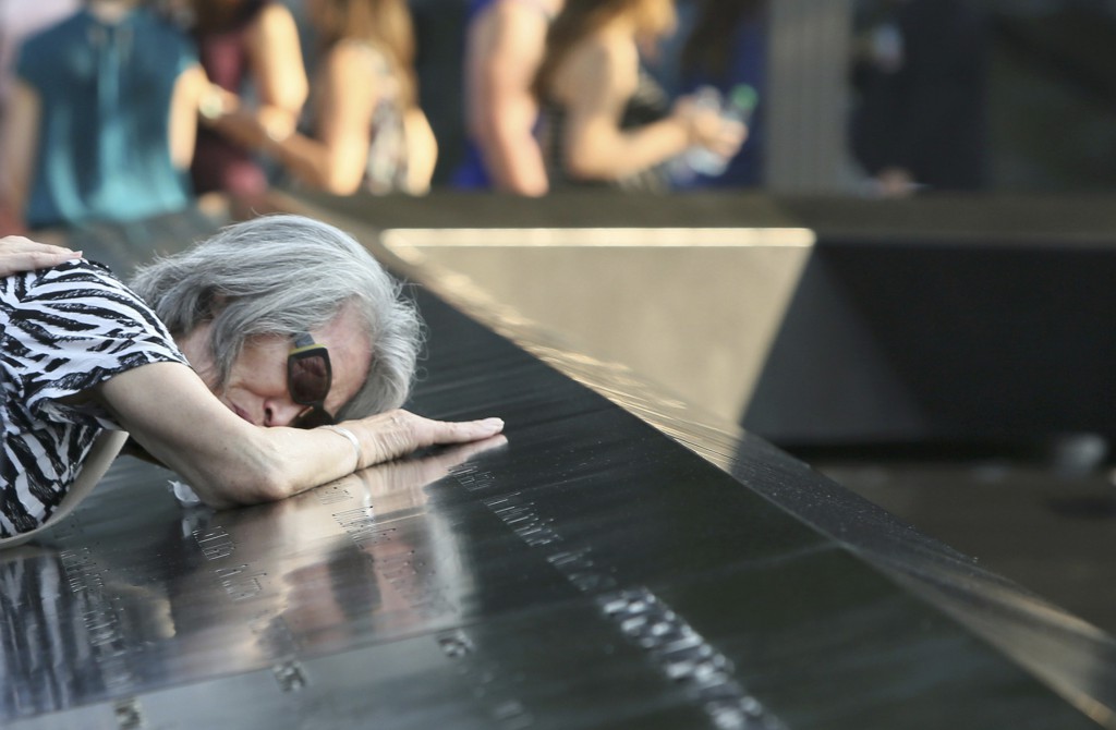 Mija Quigley of Princeton Junction, N.J., leans on an engraving of the name of her son Patrick Quigley, who died in the 9/11 attack during a ceremony marking the 12th anniversary of the attack on the World Trade Center in New York. The 2001 terrorist attacks claimed the lives of nearly 3,000 people in New York City, Shanksville, Pa., and at the Pentagon. (CNS photo/Chris Pedota, pool via Reuters) 