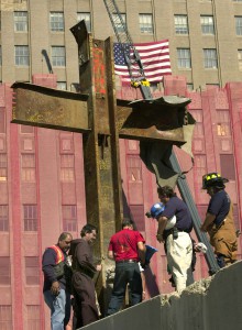 Franciscan Father Brian Jordan, standing with laborers and emergency workers in 2001, blesses a 17-foot-tall cross formed by steel beams that was recovered from the rubble of the World Trade Center in New York. (CNS photo/Kathy Willens, Reuters)