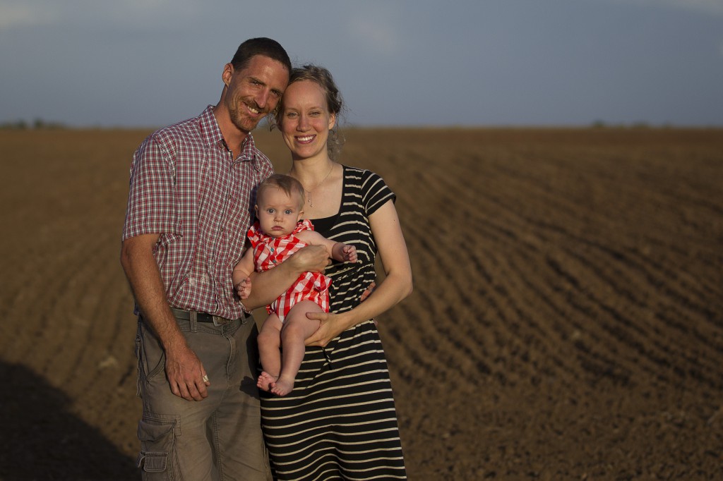 A family is pictured on a field in 2013 outside their home in Nashville, Kan. The family  and how it has changed in the last several decades will be under discussion when the extraordinary Synod of Bishops convenes at the Vatican Oct. 5. (CNS photo/Tyler Orsburn)