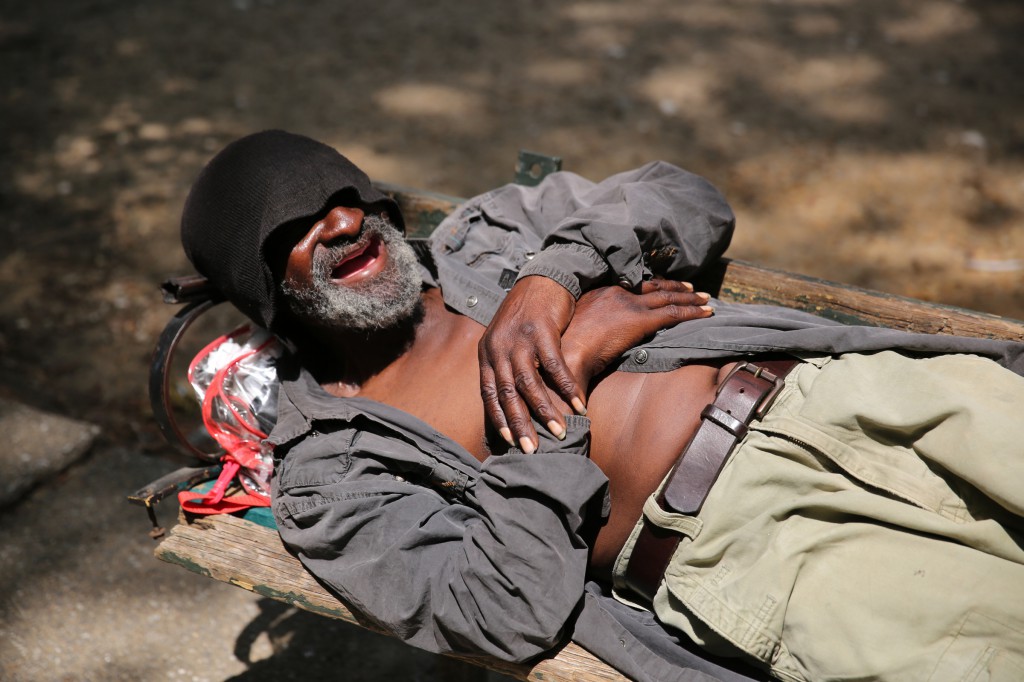 A homeless man smiles as he rests on a park bench in early July outside St. Vincent de Paul Church in Baltimore. Father Dick Lawrence and members of his urban parish, in partnership with members of Our Lady of the Fields Church in Millersville, Md., have been working with homeless people for more than 20 years. (CNS photo/Bob Roller)  