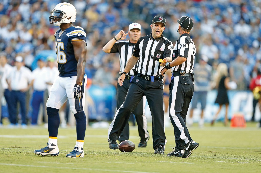 Bryan Neale, center, talks with a fellow NFL official during a pre-season game in early August between the San Diego Chargers and the Dallas Cowboys. Neale, a member of Immaculate Heart of Mary Parish in Indianapolis, has always relied on his faith on and off the field. (CNS photo/courtesy Bryan Neale)  