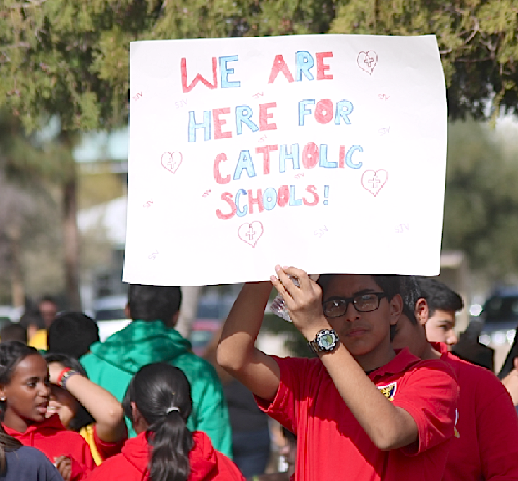 A St. John Vianney student displays a poster at a Catholic Schools Week rally earlier this year. Junior high school families are beginning to discern Catholic high schools and an info fair can help. (Catholic Sun file photo)