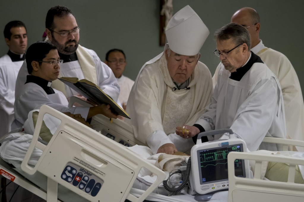 Bishop David R. Choby of Nashville, Tenn., anoints William Carmona's hands as part of the ordination rite at Christus Santa Rosa Medical Center in San Antonio Sept. 8. Carmona, gravely ill with cancer, was ordained for the Diocese of Nashville. (CNS photo/Rick Musacchio, Tennessee Register)