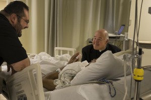 Father Gervan Menezes and Bishop David R. Choby of Nashville, Tenn., talk with seminarian William Carmona in his intensive care room at Christus Santa Rosa Medical Center in San Antonio Sept. 7. The bishop was preparing to ordain Carmona, gravely ill with cancer, as a transitional deacon and a priest for the Nashville Diocese. (CNS photo/Rick Musacchio, Tennessee Register) 