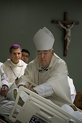 Bishop David R. Choby of Nashville, Tenn., ordains William Carmona as a deacon and a priest during a Sept. 8 Mass in an auditorium at Christus Santa Rosa Medical Center in San Antonio as Archbishop Gustavo Garcia-Siller of San Antonio looks on. Carmona, gravely ill with cancer, was ordained for the Diocese of Nashville. (CNS photo/Rick Musacchio, Tennessee Register) 