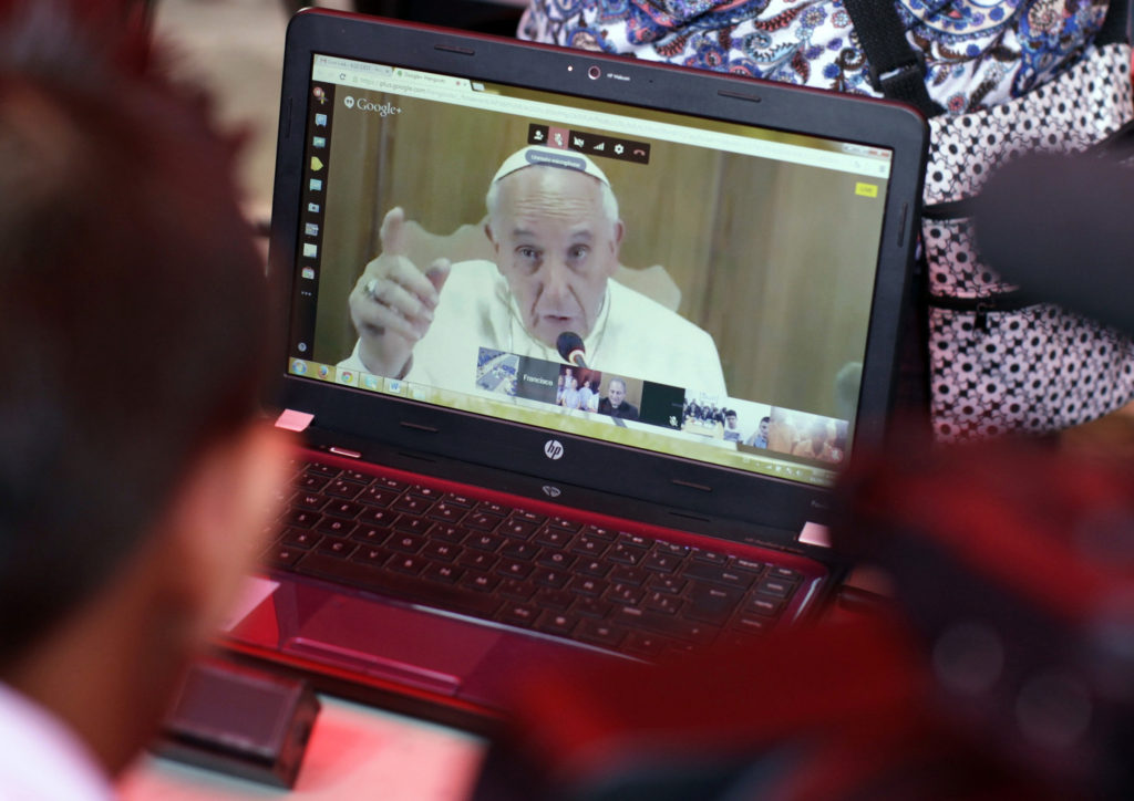 Pope Francis video chats with a Salvadoran student in the gang-infested neighborhood of La Campanera, San Salvador, Sept. 4. The pope said all of society needs to help children and young people who are homeless, exploited, victims of violence or without any prospects. (CNS photo/ Jose Cabezas, Reuters)