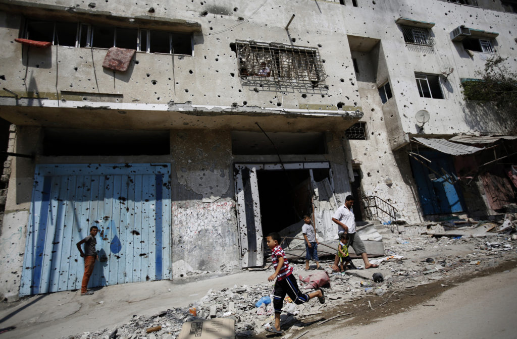 A Palestinian boy runs next to destroyed buildings in Gaza City Aug. 28. Gazans are frustrated that, despite all the sacrifice and loss of life, nothing has changed for them, except perhaps having more fishing rights, said a Catholic aid official. (CNS photo/Mohammed Saber, EPA)