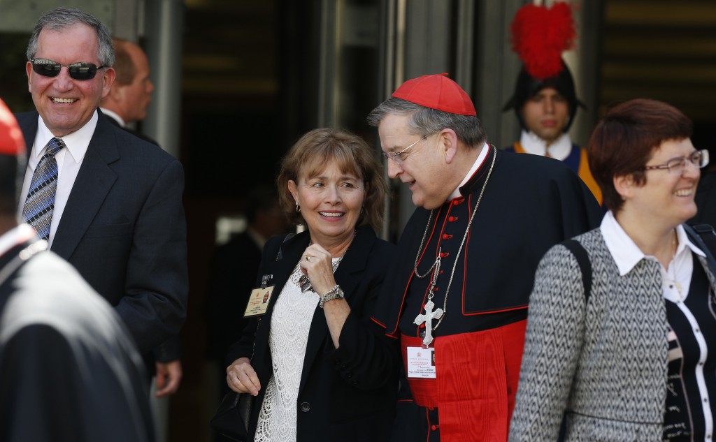 U.S. Cardinal Raymond L. Burke, prefect of the Supreme Court of the Apostolic Signature, walks with Alice and Jeff Heinzen of Menomonie, Wis., as they leave the morning session of the extraordinary Synod of Bishops on the family at the Vatican Oct. 9. The couple are auditors at the synod. (CNS photo/Paul Haring)