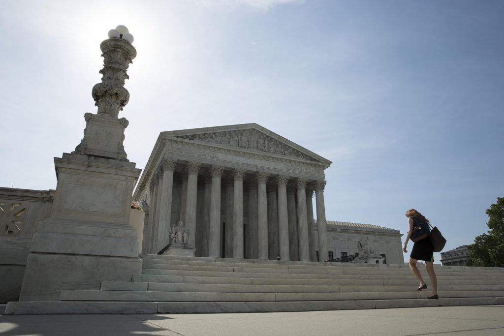 A woman walks to the U.S. Supreme Court in Washington in late June. On Oct. 6, the court declined to hear appeals on rulings striking down same-sex marriage bans. This cleared the path for same-sex marriages to be legally recognized in more states, but also caused some confusion and disappointment for those on both sides of the issue. (CNS phopto/Joshua Roberts, Reuters)