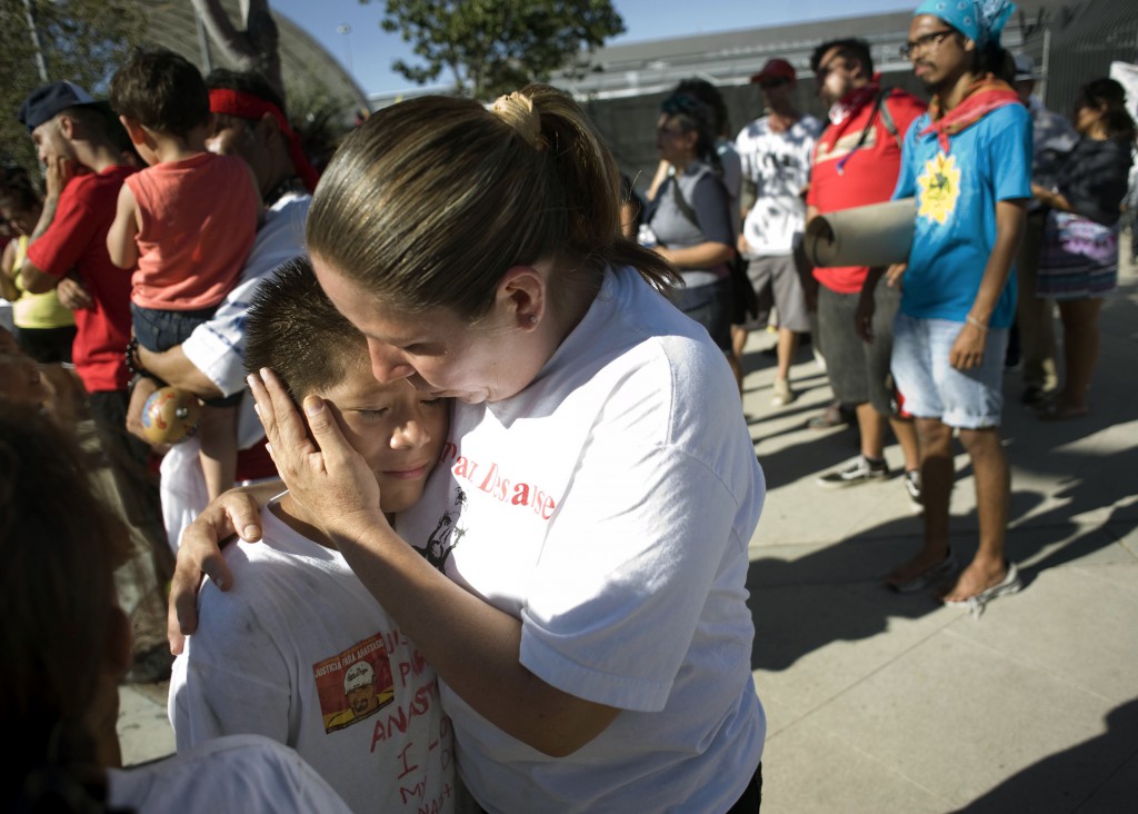 Daniel Hernandez gets a hug from his mother, Maria Puga, during an Aug. 16 rally to mark the end of the Trail for Humanity immigrant rights caravan in San Diego. The Obama administration has agreed to fund legal aid for unaccompanied minors and Catholic agencies received one of the initial grants. (CNS photo/David Maung, EPA)  