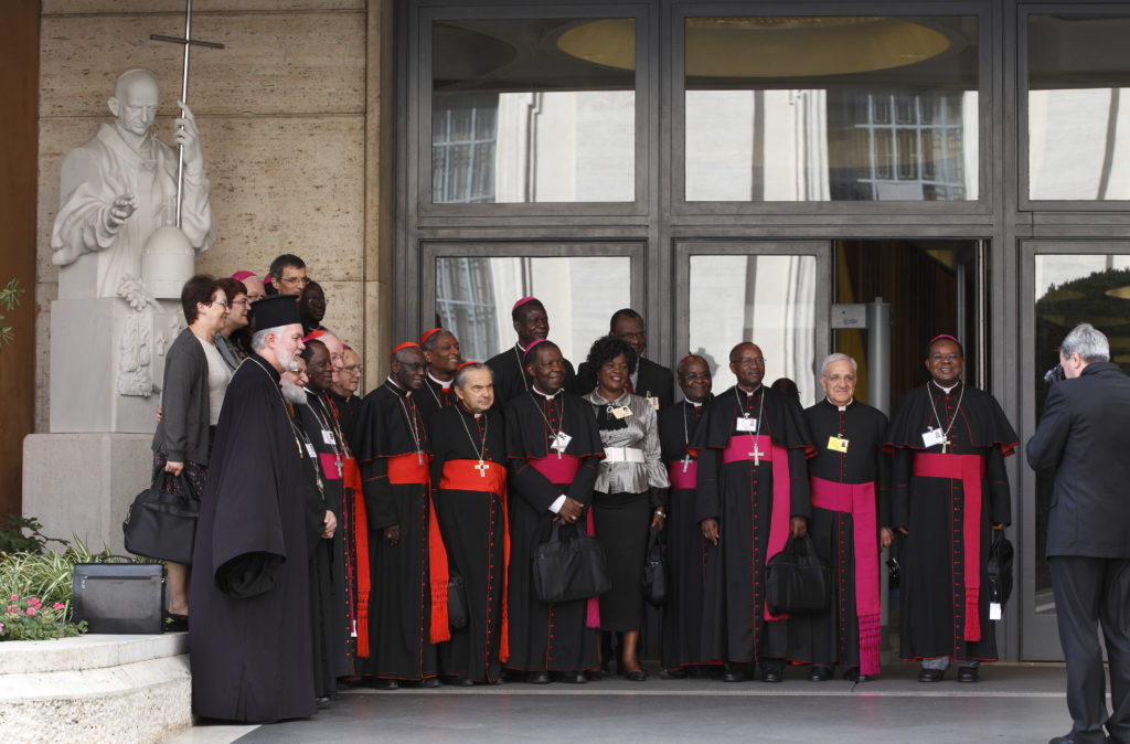 Cardinals, bishops and auditors pose outside Paul VI hall during the morning session of the extraordinary Synod of Bishops on the family at the Vatican Oct. 16. Taking the photo is Francesco Sforza, the lead Vatican photographer. (CNS photo/Paul Haring)