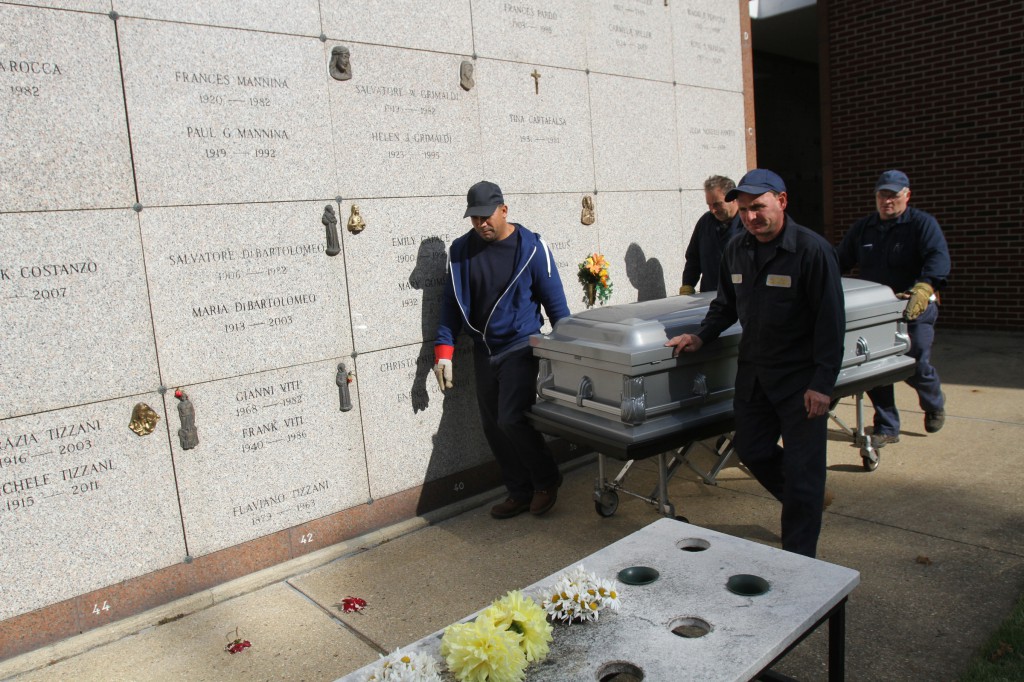 Workers prepare to entomb a casket in a garden mausoleum at Holy Rood Cemetery in Westbury, N.Y., Oct. 21. Catholic cemeteries "have a huge opportunity to evangelize and a responsibility to stand for what the church represents," says Andrew Schafer, executive director of the Archdiocese of Newark Catholic Cemeteries in New Jersey. (CNS photo/Gregory A. Shemitz)