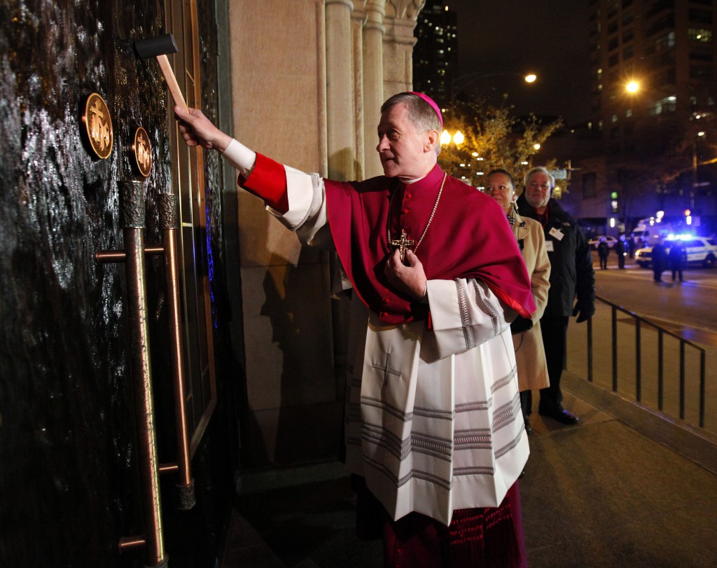 Archbishop Blase J. Cupich uses a mallet to knock three times on the doors of Holy Name Cathedral in Chicago Nov. 17. The archbishop was received inside to start the Liturgy of the Word during a rite to welcome him to the Chicago Archdiocese. (CNS photo/Karen Callaway, Catholic New World)