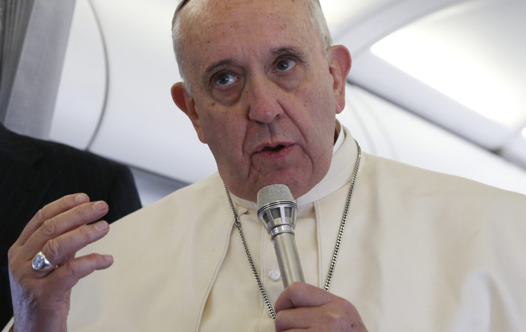 Pope Francis answers a reporter's question on his flight back to Rome after speaking at the European Parliament and the Council of Europe in Strasbourg, France, Nov. 25. Responding to a question about the remote possibility of dialoguing with terrorists such as those from the Islamic State, the pope said he would "never close the door" on dialogue. (CNS photo/Paul Haring)