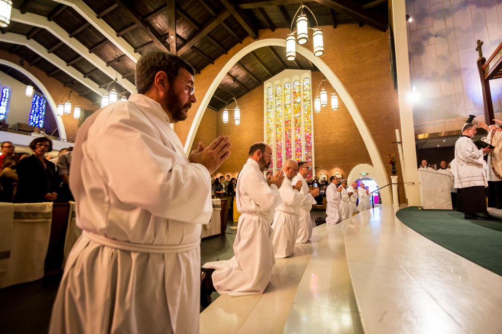Eight family men kneel at the altar of Ss. Simon and Jude Cathedral Nov. 8 during the ordination rite as they were about to become lifelong deacons for the Church. (Billy Hartman/CATHOLIC SUN)