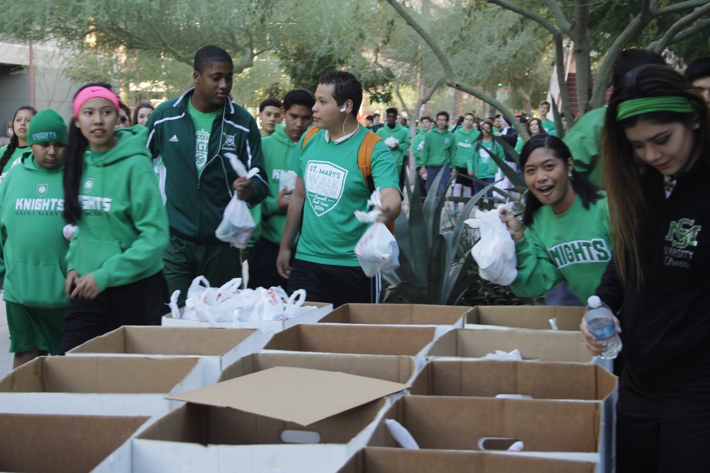 St. Mary's High School students drop off some 3,500 nonperishable food items in St. Vincent de Paul collection bins Nov. 26 outside the Diocesan Pastoral Center. The teenagers walked the food from their campus nearly two miles away. (Ambria Hammel/CATHOLIC SUN)