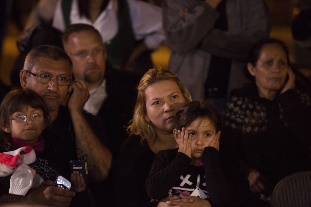 Abel and Idalia Rodriguez watch a live broadcast of President Barack Obama's national address with their daughters Nov. 20 outside the Arizona Capitol in Phoenix. The president extended a deferral of deportations to parents of millions of U.S. citizens and legal residents. (CNS photo/Nancy Wiechec)  