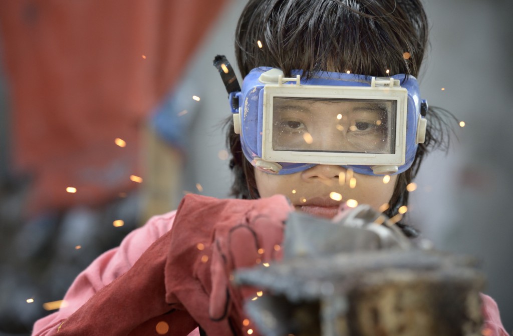 Jeddah Palo grinds smooth a weld as she participates in a welding course Oct. 24 at the San Roque Catholic Church in Tolosa, a small town in the Philippines that was devastated by Typhoon Haiyan in 2013. Palo, 24, lost her home to the typhoon's storm surge and has been living with her mother. (CNS photo/Paul Jeffrey)
