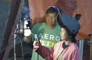 Jeddah Palo receives instruction Oct. 24 from Judgie Decadiz, the teacher of a welding course at the San Roque Catholic Church in Tolosa, a small town in the Philippines that was devastated by Typhoon Haiyan in 2013. Palo, 24, lost her home to the typhoon's storm surge and has been living with her mother.  (CNS photo/Paul Jeffrey) 